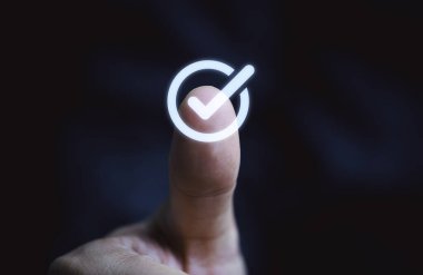 Kalite güvencesi ve garanti kavramı için el başparmağının sanal doğru işareti veya tik işareti ile kapatılması.