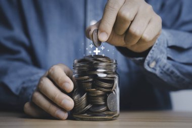 İşadamı, kar payı yatırımı ve faiz büyümesi kavramını geri getirmek için tasarruf kavanozuna artı para koyuyor..