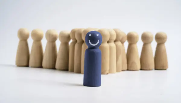Blue wooden figure smile in front of normal figure ,business leadership and successful with team member concept.