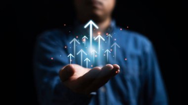 İş adamı, başarı hedefine ve kar kavramına ulaşılana kadar iş geliştirme stratejisi için ok kaldırıyor.