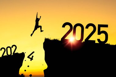 Mutlu Noeller ve mutlu yıllar 2025, Siluet Adam 2024 uçurumundan 2025 'e bulutlu gökyüzü ve güneş ışığıyla atlayan.