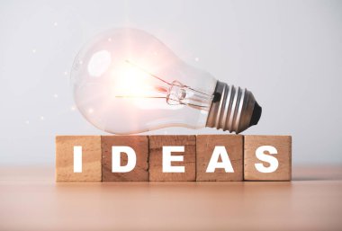Yaratıcı düşünme ve problem çözme kavramını ifade eden fikirler üzerine parlayan ampul.