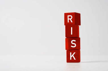 Risk yönetimi kavramını değerlendirmek için kırmızı tahta küpte risk cümlesi. 