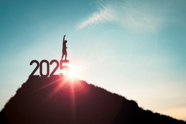 Silhouette of human standing on 2025 and the top of mountain blue sky and sunlight for start of new business year and challenge concept. clipart