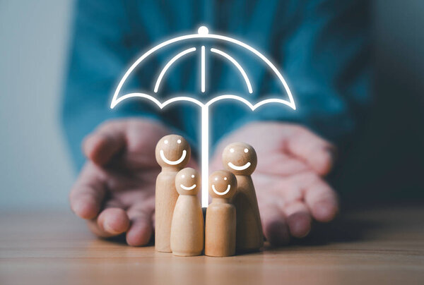 Businessman giving smile wooden figure with virtual umbrella for health lift insurance can protect in family and wellness concept.