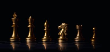 Altın satrançta kral kraliçe at gemisi ve koyu arkaplanda piyon vardır..