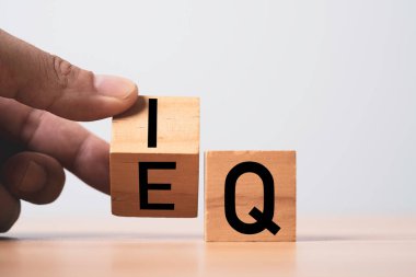 Zeka (IQ) ve duygusal zeka (EQ) kavramları arasındaki dengeyi sağlamak için el hareketi ahşap blok küp.