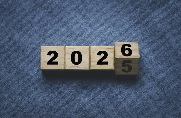 Yeni yıl değişimine hazırlık için ahşap blok küpünde 2025 'ten 2026' ya çevirme ve yeni iş hedefi stratejisi kavramına başlama.