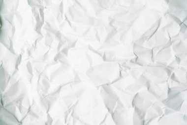 Buruşuk beyaz kağıdın yakın plan görüntüsü, dokusunu ve ince gölgelerini gözler önüne seriyor. Düzensizlikler derinlik ve karmaşıklık hissi yaratıyor, sanatsal arka planlar veya minimalist tasarımlar için mükemmel.