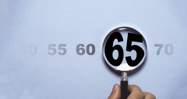 Büyüteç, genişleme emeklilik kavramının analizini ve odak noktasını sembolize eden sayıların gradyanı karşısında 65 sayısını vurguluyor..