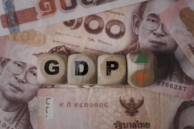 Tayland baht banknotunun yukarı ve aşağı okunu değiştirmek için tahta blok küpünü çevirmek Tayland gayri safi yurtiçi hasıla veya Gayrisafi Yurtiçi Hasıla artışı ve azalan kavram.