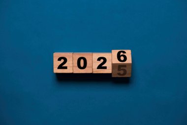 Yeni yıl değişimine hazırlık için ahşap blok küpünde 2025 'ten 2026' ya çevirme ve yeni iş hedefi stratejisi kavramına başlama.