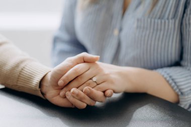 El ele tutuşan çiftin yakın plan görüntüsü, kadın ve erkek el ele tutuşuyor, yazın parkta yürüyorlar, aşk ve aile kavramı, seçici odaklanma.