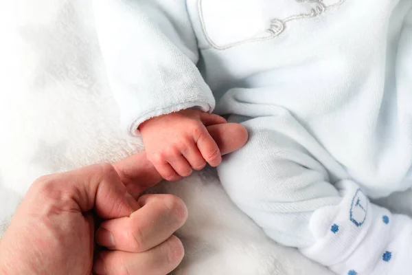 Close Van Een Hand Van Een Pasgeborene Met Witte Kleren Stockfoto