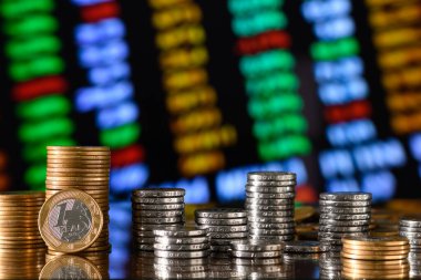 Borsa ve grafiğin arka planında para yığını.