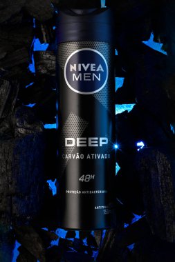 Nivea Men Derin etkin kömür antiterletici parfüm, arka planda mavi ışık olan bir kömür parçası üzerinde