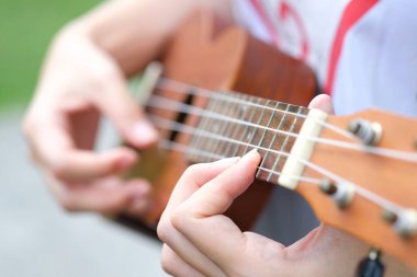 Yazın gitar çalan genç bir kadın.