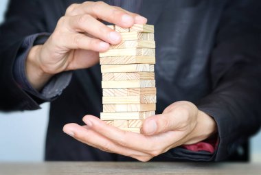 İş ve yatırım için başarı adımları. İş adamı, yüksek, iş konsepti ve başarılı yatırım konseptini artırmak için tahta blok düzenliyor.