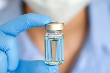 Doktor eli, elinde bir şişe antiretroviral ilaç tutuyor, mavi su. Sağlık ve tıbbi kavramlar