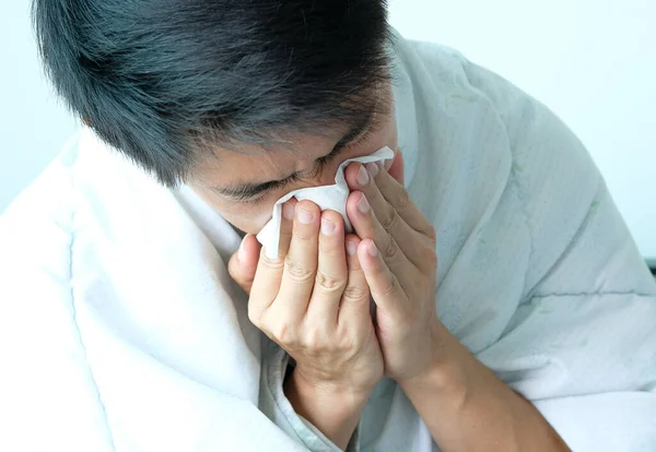 病人是流感 用纸巾 他流鼻涕 他身上还穿着保暖的衣服 — 图库照片