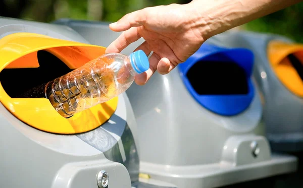 stock image Please dispose of plastic bottle into the tank. A man throw rubbish in the trash can by separate garbage to dispose like hazardous waste ,