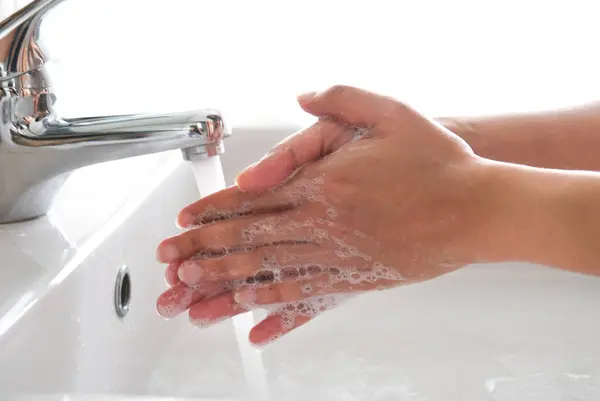 hand of beauty woman  wash your hands at the wash basin with foam, cleanse the skin and have water flowing through the hands. Health and beauty concepts