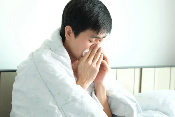 病気の男は 紙ナプキンを使用して インフルエンザであり 彼は鼻水を持っています 彼は暖かい服で覆われていました — ストック写真