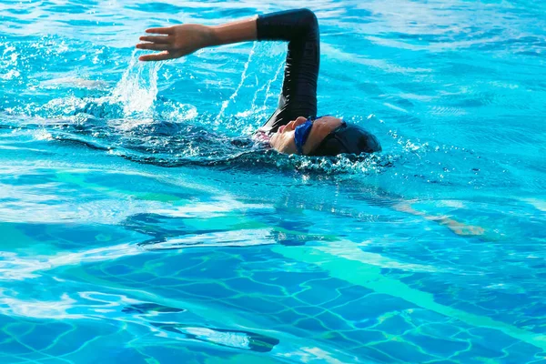 Women swim in a freestyle swimming style that is standard swimming.
