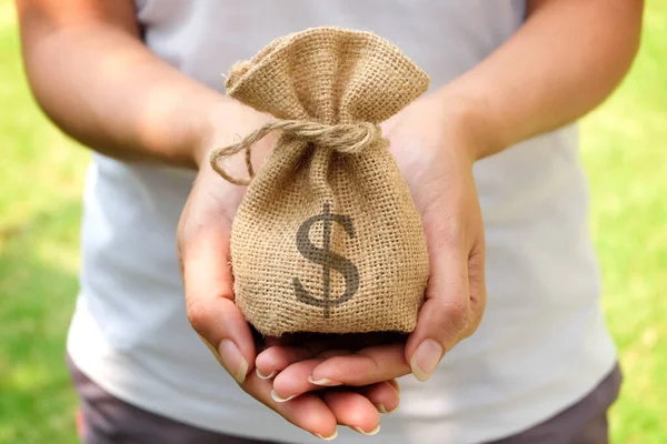 Hand of a woman carrying a purse money .concept saving money and investment concept