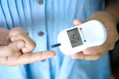 İnsanların elleri diyabet ve yüksek kan şekeri monitörlerini dijital basınç göstergesi ile kontrol ediyor. Sağlık ve Tıp Konsepti