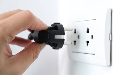 Elektrik Cihazları 'nın Eli fişi çekiyordu. Fişi çek. Çalışma saatlerinde ofisinde. Enerji Tasarruf Kavramları ve Teknolojileri