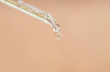 hands of a beautiful woman Dropping serum collagen moisturizer of face into clear gold bottle soft light background. Protector skin Treatment facial essence oil, Vitamin C. Beauty and spa Concept