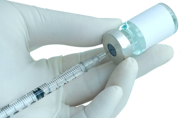 doctor's hand holds a syringe and a blue vaccine bottle at the hospital. Health and medical concepts
