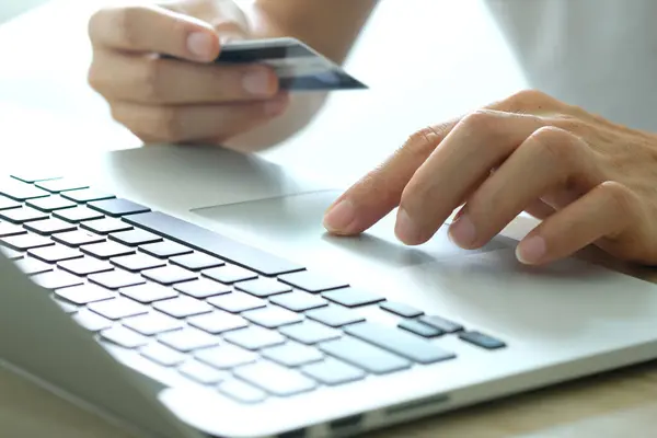妇女手持信用卡 使用电脑键盘记事本 网上购物概念 图库图片