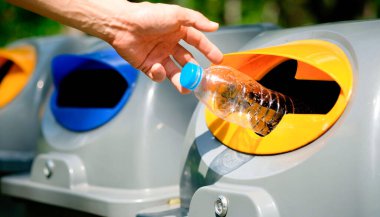 Lütfen plastik şişeyi depoya atın. Bir adam çöp tenekesine çöp atar gibi çöp atmak için çöpleri ayırır. ,