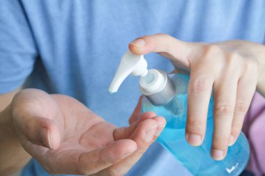 Ellerini temizliyor ve bulaşıcı hastalıkların bulaşmasını önlemek için mikropları alkol jeliyle öldürüyor. Ve Coronavirus covid-19 'un önlenmesi.