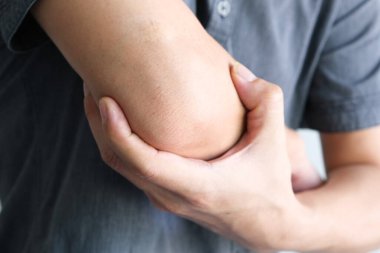 Erkekler dirseklerini tutmak için ellerini kullanır ve dirseklerinde ağrı vardı. Acı verici Sağlık ve Tıbbi Konseptler
