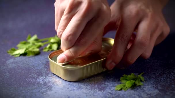 Hands Opening Can Sardines Tomato Sauce Dark Blue Table Parsley — стоковое видео
