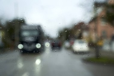 Road in heavy rain. Water falling or raining in front of the car on the road or street. Driving car in rain. Blurred background.