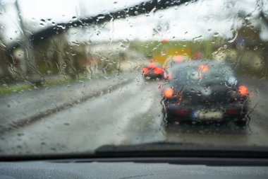 Bad weather driving on a in the city. Raindrops on the car glass.