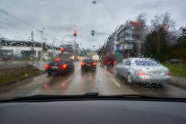 Raindrops on the windshield. Rush hour traffic in the city. Cockpit view.