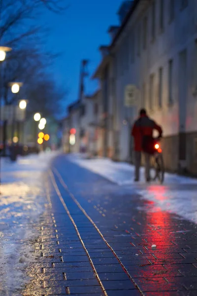 Icy and slippery (Blitzeis, Glatteis) sidewalk in cold city. Danger from ice and snow for cyclists and pedestrians. In the early winter morning. Germany, Nurtingen.