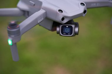 Nurtingen, Almanya - 26 Haziran 2021: Dji Air 2 'nin insansız hava aracı. Algılayıcıları ve 1 inçlik kamerası olan gri bir çoklu helikopter. Yeşil çayır alan derinliği. Yüksek açı. Almanya.