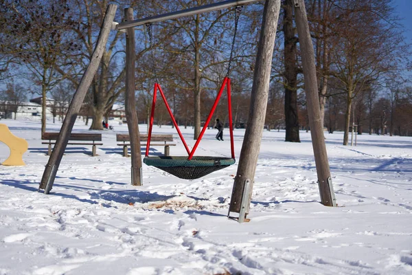 Nagy Swing Játszótéren Parkban Fák Épület Háttérben Piros Dominál Kék — Stock Fotó