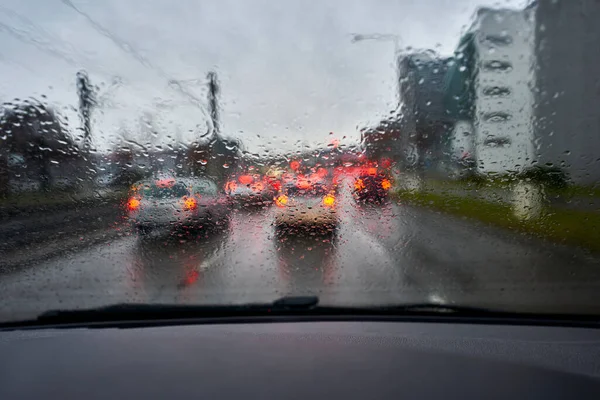 Ön cama yağmur damlaları damlıyor. Şehirde trafik sıkışıktı. Kokpit manzaralı. Trafik sıkışık..