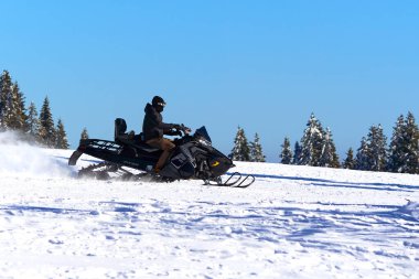 Feldberg, Germany - February 08, 2023: Snowmobile Polaris Titan 800. Vehicle for universal use under extreme operating conditions.Winter in black forest. Driving on the ski slope. clipart