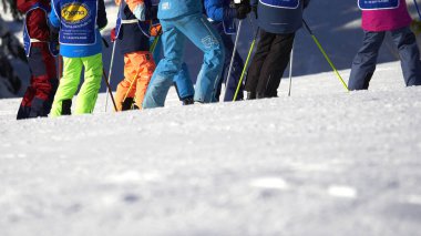 Feldberg, Almanya - 08 Şubat 2023: Dersler sırasında kayak okulu Thoma. Öğretmen ve çocuklar dağda kışın spor giysileri giyerler. Karda hobi. Kayak kursu. Arka görünüm.