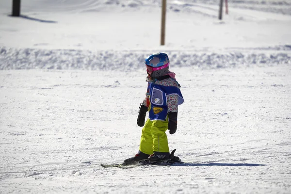 Feldberg, Almanya - 08 Şubat 2023: Kayak başlangıcı karda yokuş aşağı kayak yapıyor. Kayak okulunda kış sporları öğrenen küçük bir çocuk. Kayak kursu.