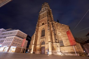 Stuttgart, Almanya - 26 Aralık 2023: Almanya 'nın Stuttgart kentindeki önemli bir kilise olan aydınlanmışların karanlık gökyüzüne karşı gece görüşü. Almanya, Stuttgart.