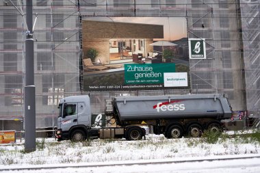 Stuttgart, Germany - December 16, 2022: Construction site truck in front of scaffolding on a new building. Creation living space in the city. clipart